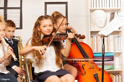 Group Of Kids Playing Musical Instruments Indoors Stock Photo