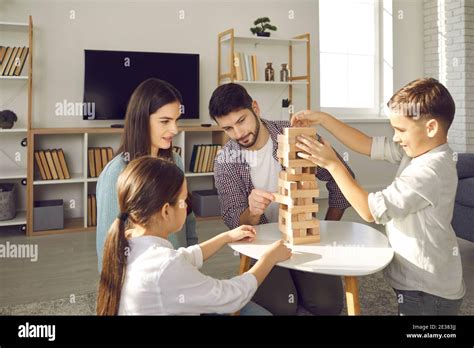 Concentrated Parents And Children Playing Jenga While Enjoying Free