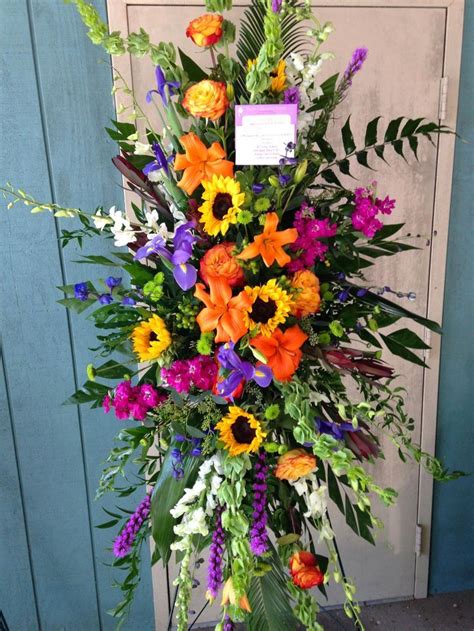 colorful standing funeral spray with sunflowers orange roses and lilies with p memorial