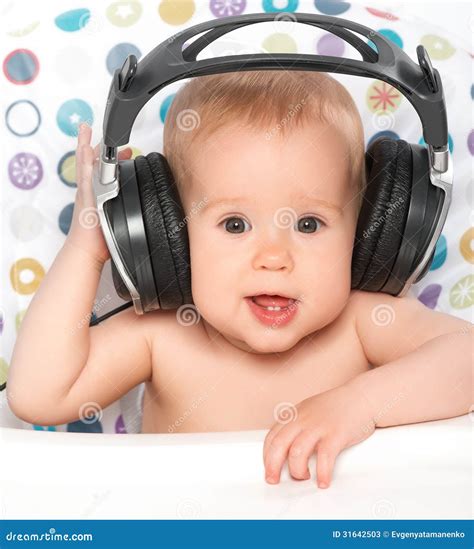 Bebé Feliz Con Los Auriculares Que Escucha La Música Fotos De Archivo