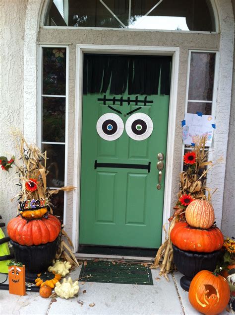 A Front Door Decorated For Halloween With Pumpkins And Decorations