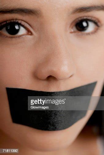 Portrait Of A Young Woman With Adhesive Tape Over Her Mouth Photo