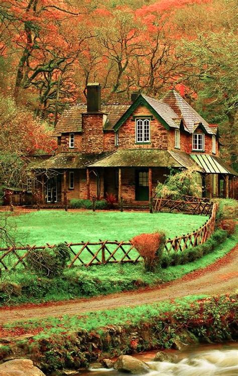 A House In The Middle Of A Field Next To A Stream And Trees With Orange