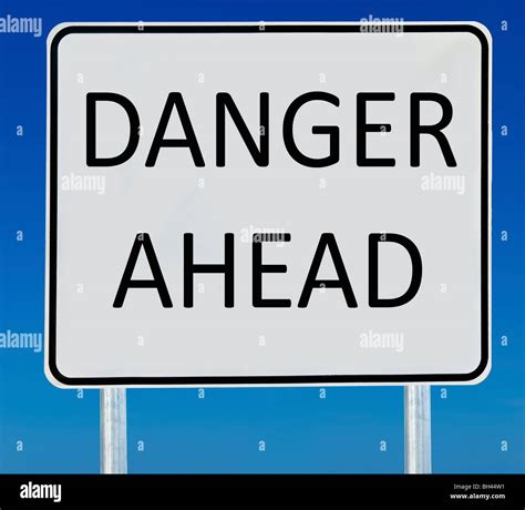 A Danger Ahead Road Sign Isolated On A Blue Graduated Sky Stock Photo