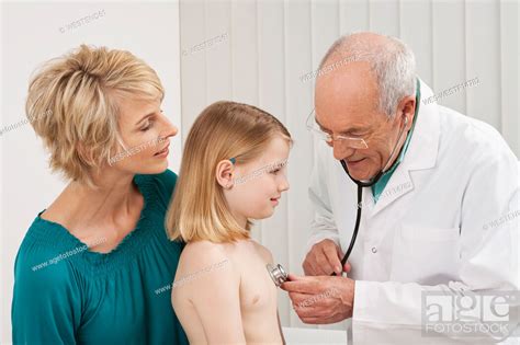 Germany Munich Doctor Examining Girl 8 9 With Woman Stock Photo