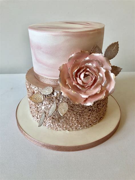 A Pink And Gold Wedding Cake With Flowers On Top