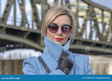 a beautiful blonde woman of 40 45 years old smiles against the background of metal structures of