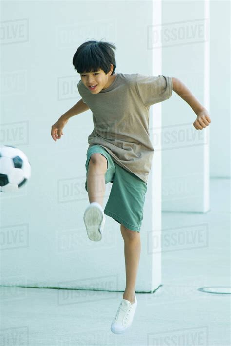 Boy Kicking Soccer Ball Full Length Stock Photo Dissolve