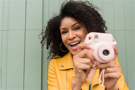 woman taking photo with pink polaroid camera by stocksy contributor jamie grill atlas stocksy