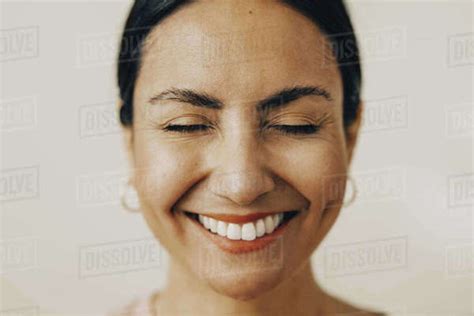 Cheerful Mid Adult Woman With Eyes Closed Against White Background
