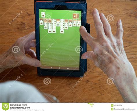 Elderly Woman`s Hands Playing Solitaire On A Tablet Editorial Stock