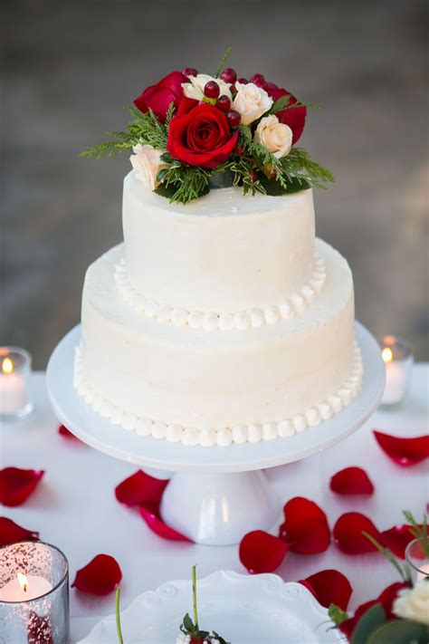 the two tiered wedding cake was beaded at the bottom of each tier and topped with ivory and red