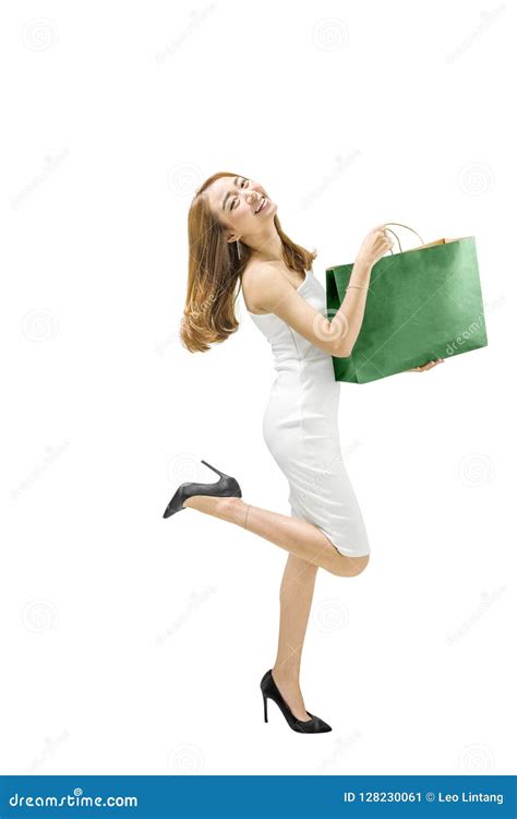 Smiling Asian Woman In White Dress Holding Green Paper Bag Stock Image