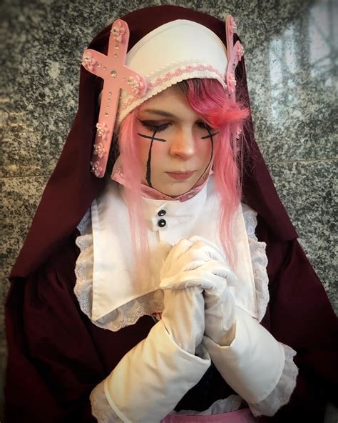 A Woman With Pink Hair Wearing A Nun Outfit And Cross On Her Forehead