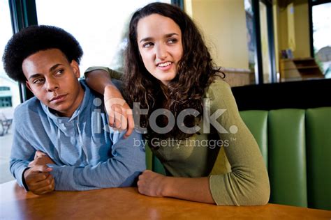 Pareja Adolescente Interracial Sentados Juntos En El Comedor Fotografías De Stock