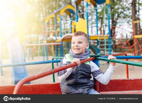 Little Boy Play On Playground With Blur Park Background Stock Photo By