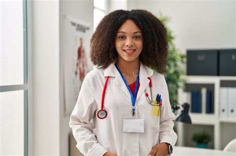 Young African American Woman Wearing Doctor Uniform Standing At Clinic