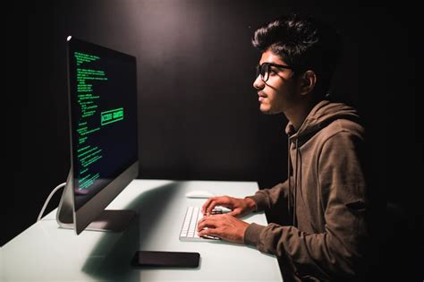 Free Photo | Male indian programmer working on desktop computer at white desk in office.