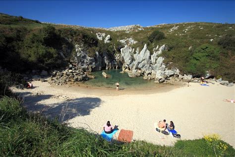 playa de gulpiyuri a sandy beach in the middle of a meadow the adventourist cool travel
