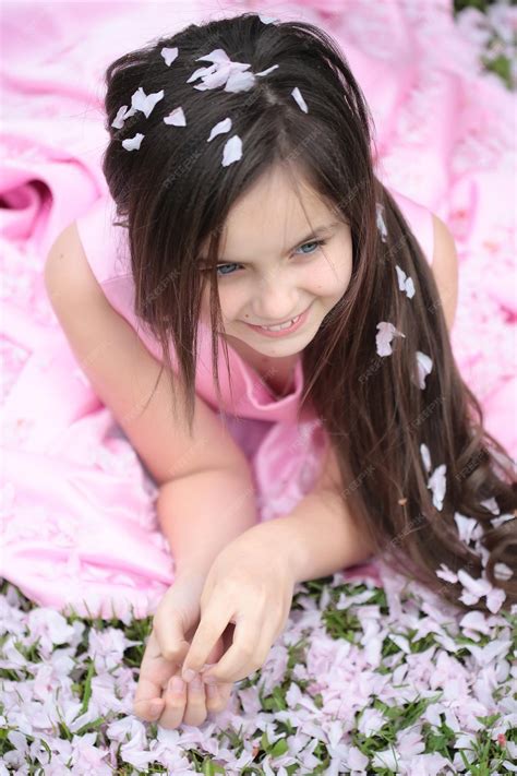 Premium Photo Little Girl On Green Grass With Petals