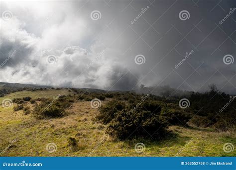 Dramatic Landscape Of Storm Clouds Fog And Grassy Meadow And Hills