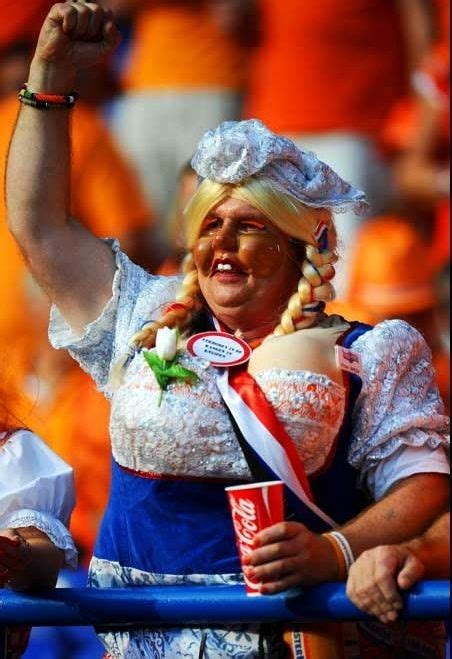 A Woman With Blonde Hair And Glasses Is Holding Up A Soda In Her Hand
