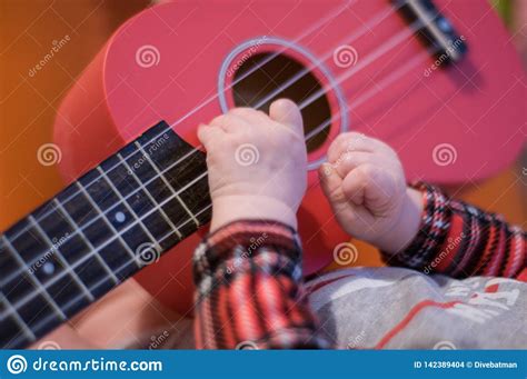 Baby Fingers Plays Guitar Ukulele Strings And Frets Stock Photo