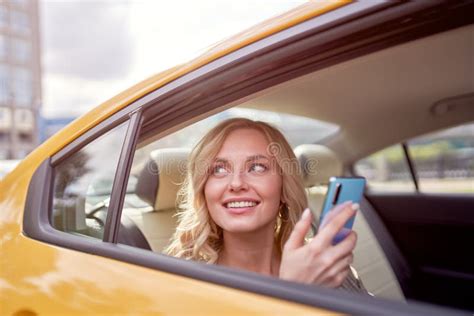 Image Of Happy Blonde Looking At Side With Phone In Her Hand Sitting In