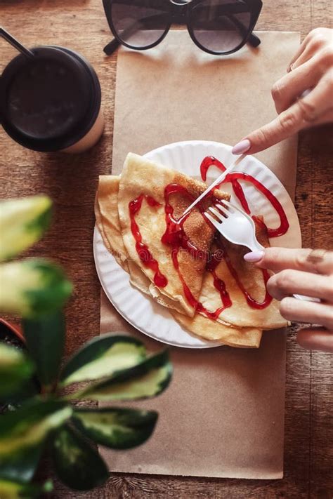 Pancakes Drizzled With Red Syrup On A Plate In A Restaurant Breakfast