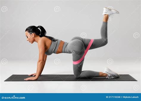 Athletic Girl Doing Kickback Exercise For Glutes With Resistance Band Fitness Woman Working Out