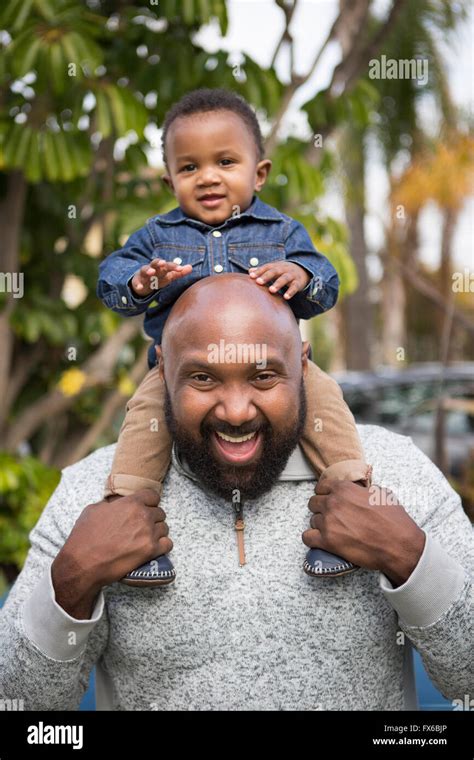 African American Father Carrying Son On Shoulders Stock Photo Alamy