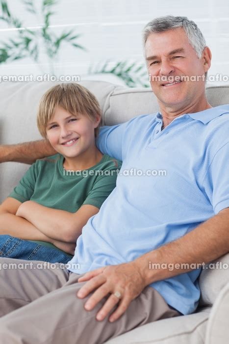 Portrait Of Grandson And Grandfather Sitting On The Couch In The Living