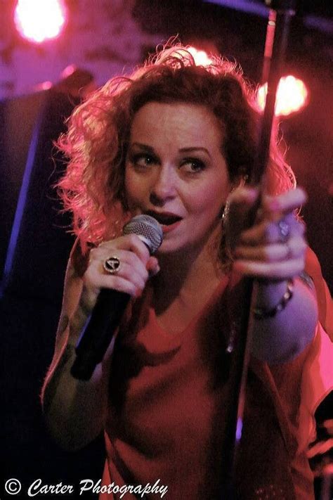 A Woman Holding A Microphone In Her Right Hand