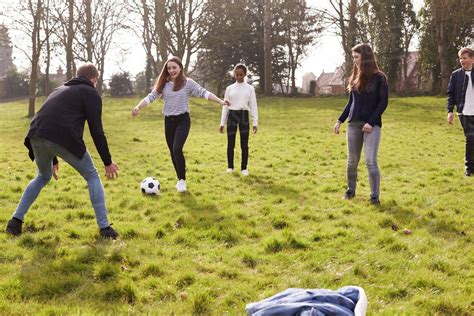 Group Of Teenagers Playing Soccer In Park Together Stock Photo Dissolve