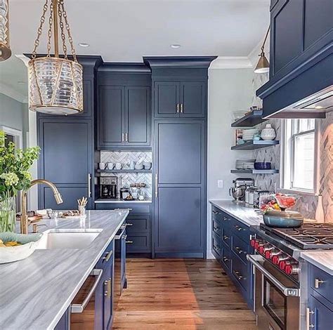 A Kitchen With Blue Cabinets And Wooden Floors