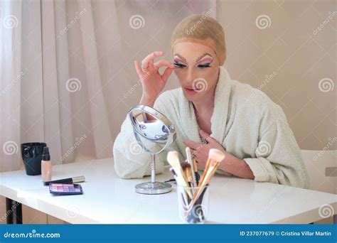 Drag Queen Person Applying False Eyelashes And Wearing Bathrobe Stock