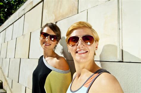 Two Beautiful Woman With Sunglasses On Stone Wall Background Stock