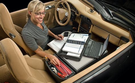 A Woman Is Sitting In The Back Seat Of A Car With Her Laptop And Notebook