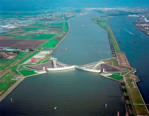 An Aerial View Of A Large Body Of Water With Two Piers In The Middle And Green Fields On Both Sides