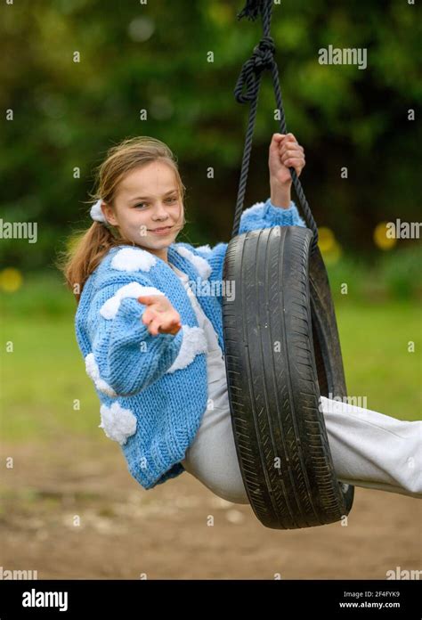 Girl Swinging On A Tyre Swing Stock Photo Alamy
