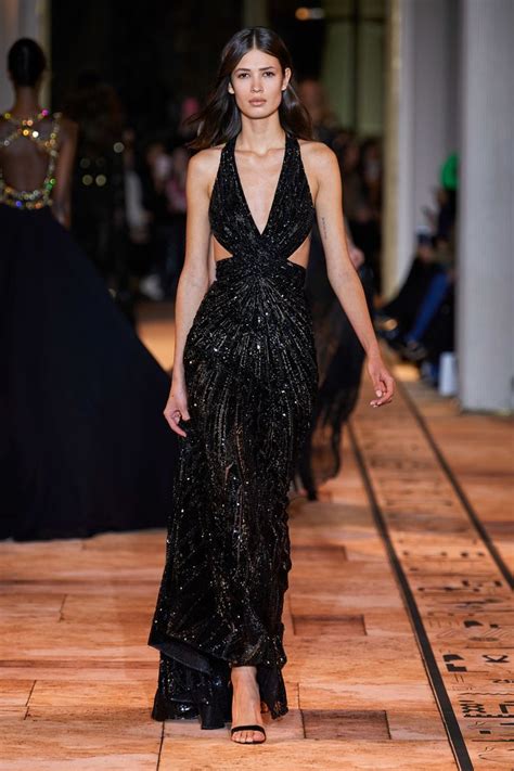 A Model Walks Down The Runway In A Black Gown