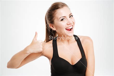 Smiling Joyful Fitness Girl In Sportwear Showing Thumbs Up With One Hand Over White Background