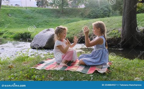 Two Teenage Girls Play With Each Other Clapping Their Hands While