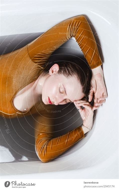 Woman Lying In Bathtub Filled With Charcoal Water A Royalty Free