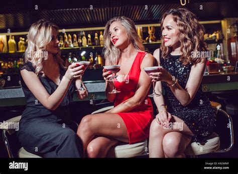 Beautiful Women Are Sitting On The Bar And Drinking Cocktails Stock Photo Alamy