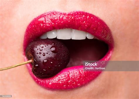 Red Lipstick On Lips And A Cherry With Water Droplets The Girl Is