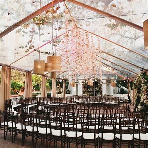 The Inside Of A Tent With Rows Of Chairs Set Up For An Outdoor Wedding