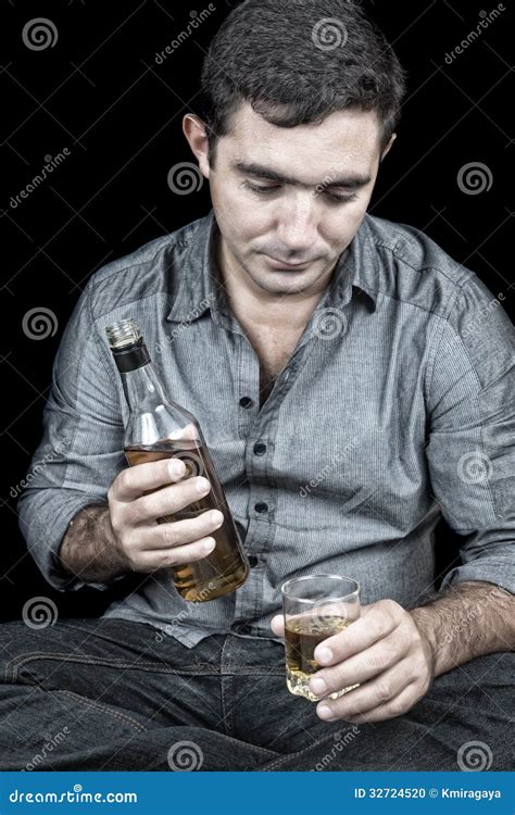 Drunk And Depressed Hispanic Man With A Black Background Stock Photo