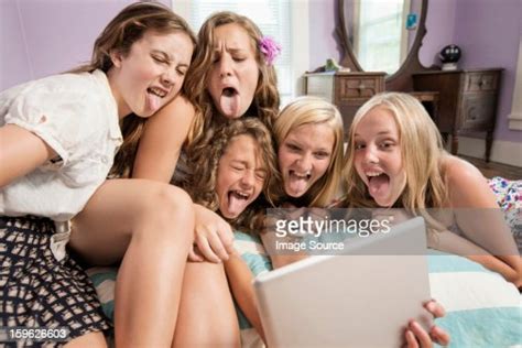 Girls Looking At Digital Tablet Sticking Out Tongues Photo Getty Images