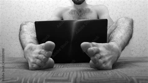 Picture Of Young Naked Man With Hairy Legs Sit On Sofa And Hold Laptop
